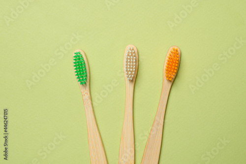 Bamboo toothbrush on a green background.