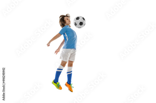 Portrait of little male football soccer player, boy training with football ball isolated on white studio background. Concept of sport, game, hobby