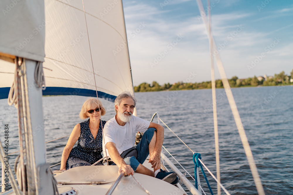 Romantic vacation and luxury travel. Senior loving couple sitting on the yacht deck. Sailing the sea. Romantic vacation and luxury travel. Senior loving couple sitting on the yacht deck. Sailing the sea.