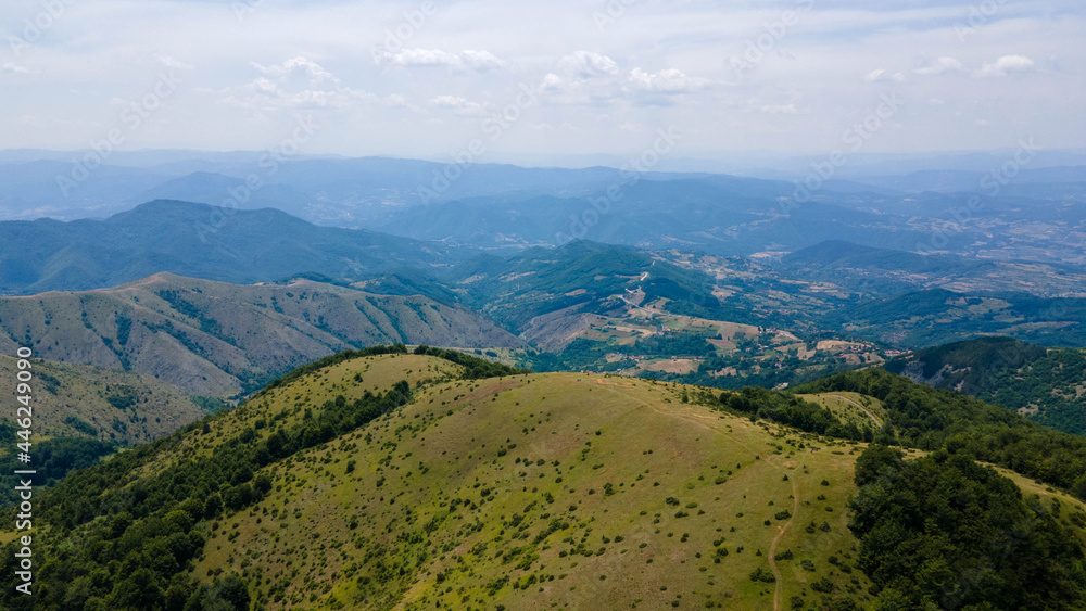 Aerial view of green mountain hills covered with evergreen spruce forest in summer. aerial view of dramatic mountains landscape on cloudy day, Serbia.