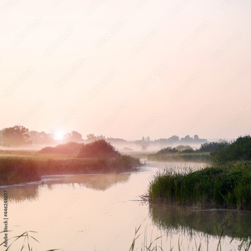 Fototapeta premium Sunrise in a light fog on a small river. Selective Focus