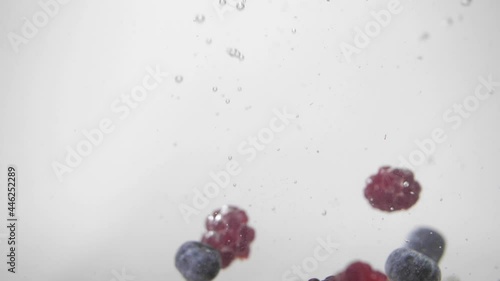 Raspberry, blueberry, raspberries falling in to the water photo