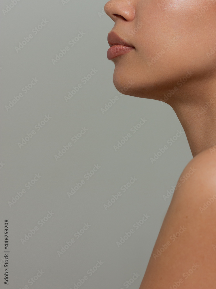 Close-up portrait of beautiful woman's purity face with nude lips make-up. Cute model with clean shiny skin and long neck. The place for your text, a gray background. Gives a kiss Close-up portrait of beautiful woman's purity face with nude lips make-up. Cute model with clean shiny skin and long neck. The place for your text, a gray background. Gives a kiss