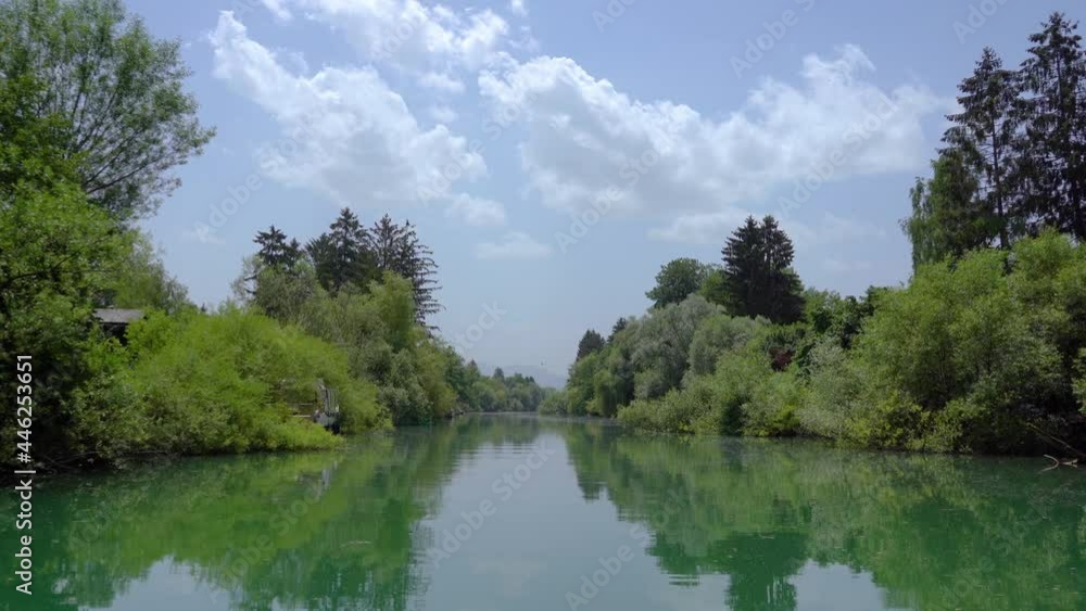 Navigating on Ljubljanica river near Ljubljana city, Slovenia. Unique perspective of green suburb on hot summer day. Trees covering river bank. Real time, forward moving, wide angle Navigating on Ljubljanica river near Ljubljana city, Slovenia. Unique perspective of green suburb on hot summer day. Trees covering river bank. Real time, forward moving, wide angle