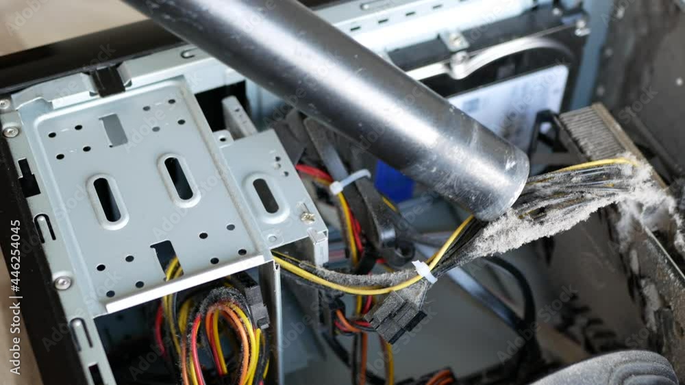 Removing dust buildup on the power cords with a vacuum cleaner. Dusting off the components of system unit case. Person is cleaning the inside of the computer Removing dust buildup on the power cords with a vacuum cleaner. Dusting off the components of system unit case. Person is cleaning the inside of the computer
