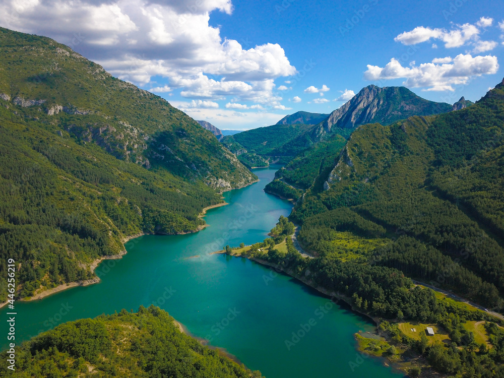 Aerial drone view of an idyllic and natural valley with a big lake in the mountains of north Spain.