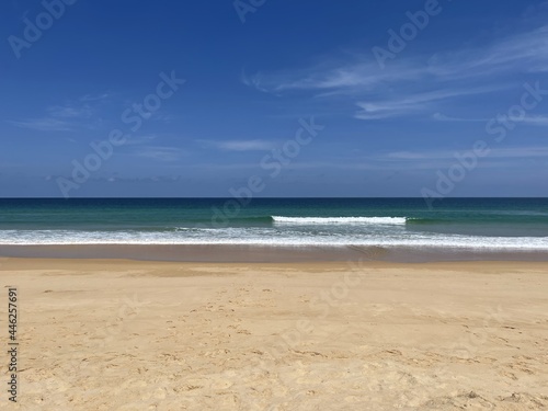 Waves on the sea. Beautiful panoramic view. Line of horizon  blue sky  turquoise water  yellow clean sand. White foam of waves. Open ocean. Seascape  panorama. Tropical paradise. Thailand. Indonesia. 