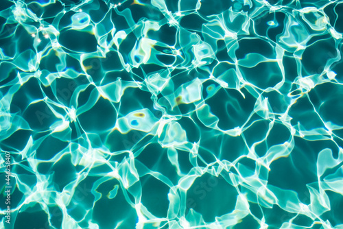 Sunflecks on emerald water surface in a swiming pool