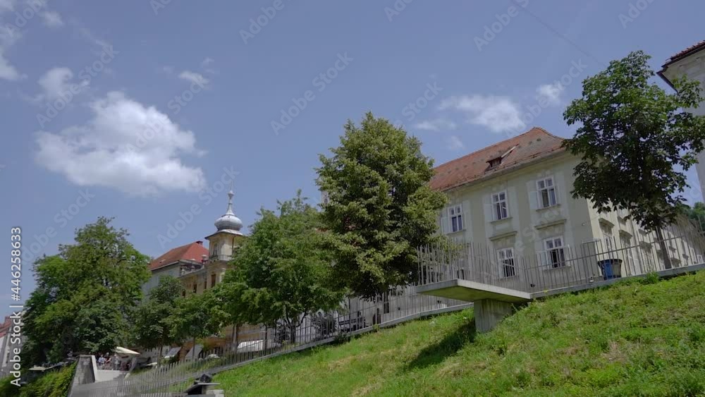 Cityscape view from boat, Ljubljana, Slovenia. Navigating on Ljubljanica river. Unique perspective of medieval downtown in hot summer day. Looking up on trees and historic buildings. Slow motion Cityscape view from boat, Ljubljana, Slovenia. Navigating on Ljubljanica river. Unique perspective of medieval downtown in hot summer day. Looking up on trees and historic buildings. Slow motion