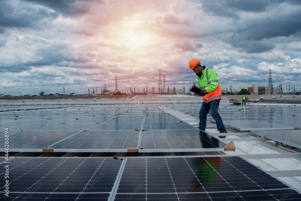 inspection engineer checking solar panel on roof with flare light. worker on construction site