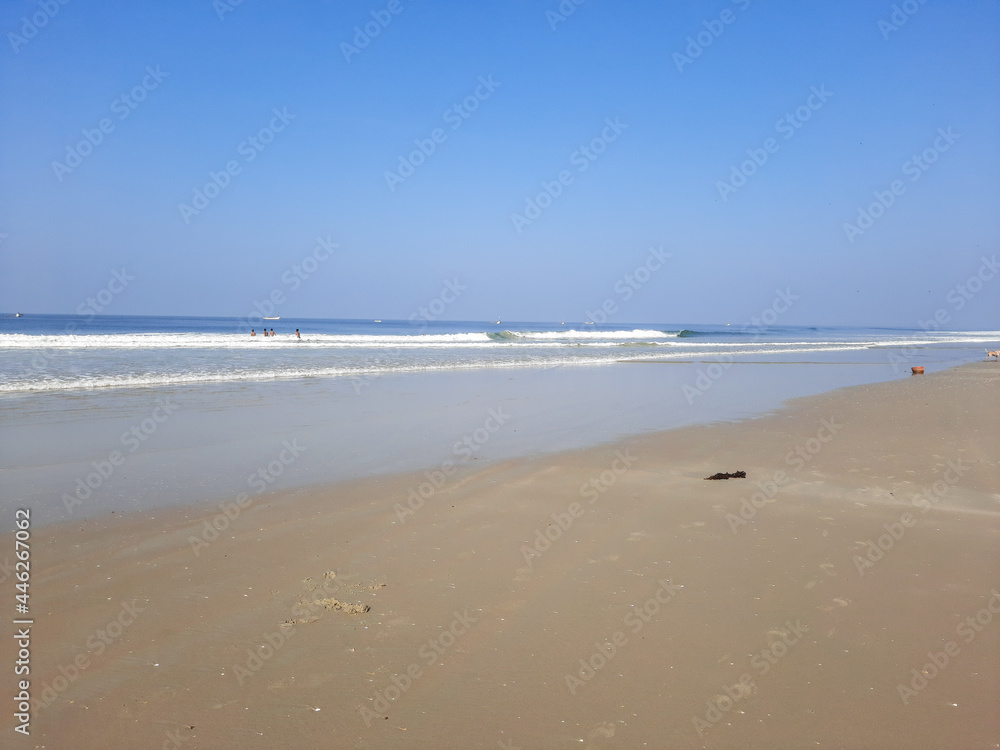 Colva beach in goa, palm tree in beach, tropical beach, blue water and blue sky Arabian sea beach in India, white sand and blue water.