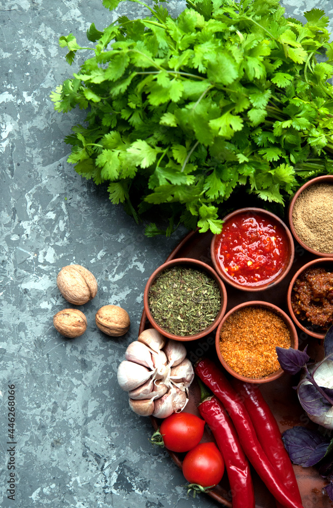 Georgian spices in clay jars on a plate.
Georgian spices in clay jars on a plate.