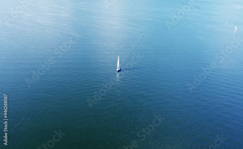 Aerial view of a white yacht with a sail. Ship in the blue sea © Payllik