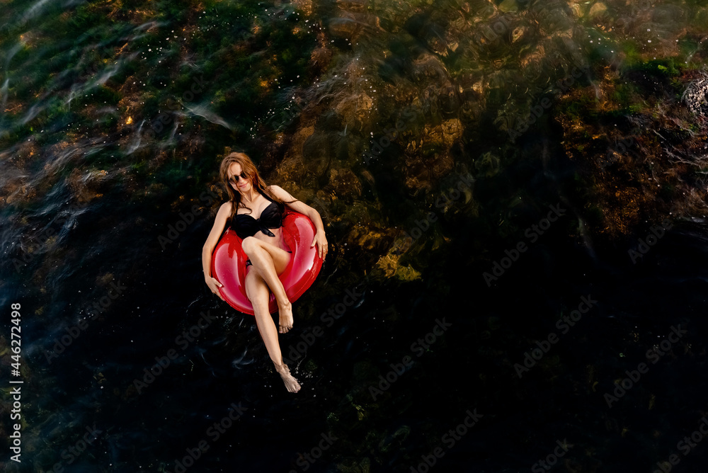 Sexy woman swims on pink inflatable ring on the islands. Photo Summer vacation. Top view. Space for text. Sexy woman swims on pink inflatable ring on the islands. Photo Summer vacation. Top view. Space for text.