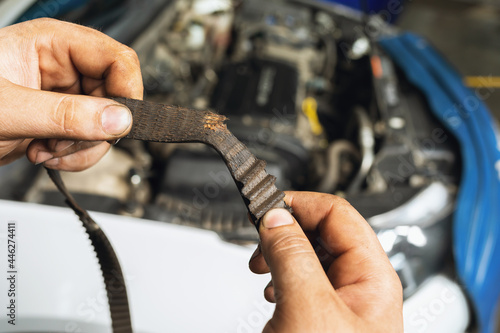 Quadro em tela An auto mechanic shows a torn timing belt with worn teeth against the background