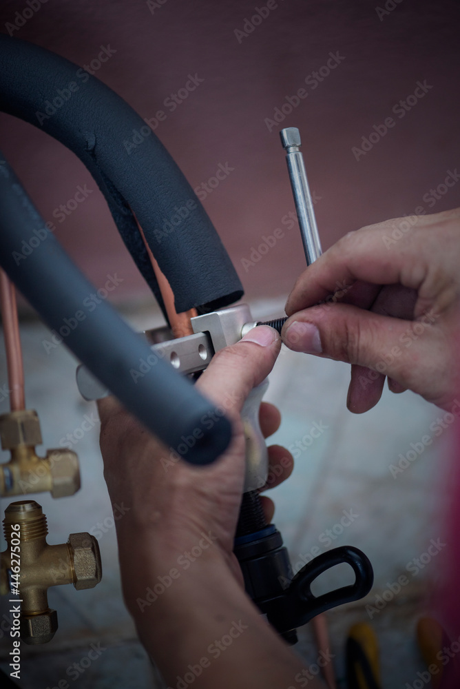 Image of Air conditioner technician is connecting pipes to bring home air conditioners.,air conditioning equipment. Image of Air conditioner technician is connecting pipes to bring home air conditioners.,air conditioning equipment.