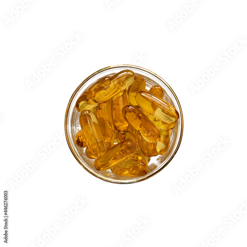 Omega 3 fish oil capsules in glas cup isolated on white background. Top view.