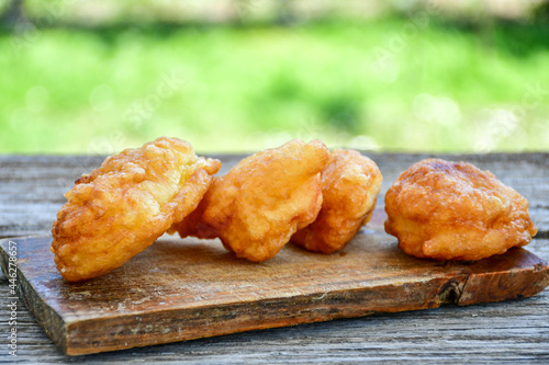 Traditional Bulgarian home made deep fried  patties  covered with sugar  оn rustic backgroud.Mekitsa or Mekica,  on wooden  rustic  background. Made of kneaded dough that is deep fried  photo