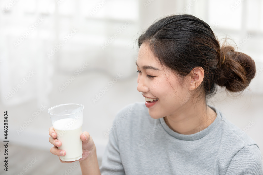 Healthy Young Asian woman Drinking milk with calcium for strong bone at home,Smiling indian woman holding soy milk on glass enjoy with nutrition wellness life,Wellness with natural milk fresh Concept Healthy Young Asian woman Drinking milk with calcium for strong bone at home,Smiling indian woman holding soy milk on glass enjoy with nutrition wellness life,Wellness with natural milk fresh Concept