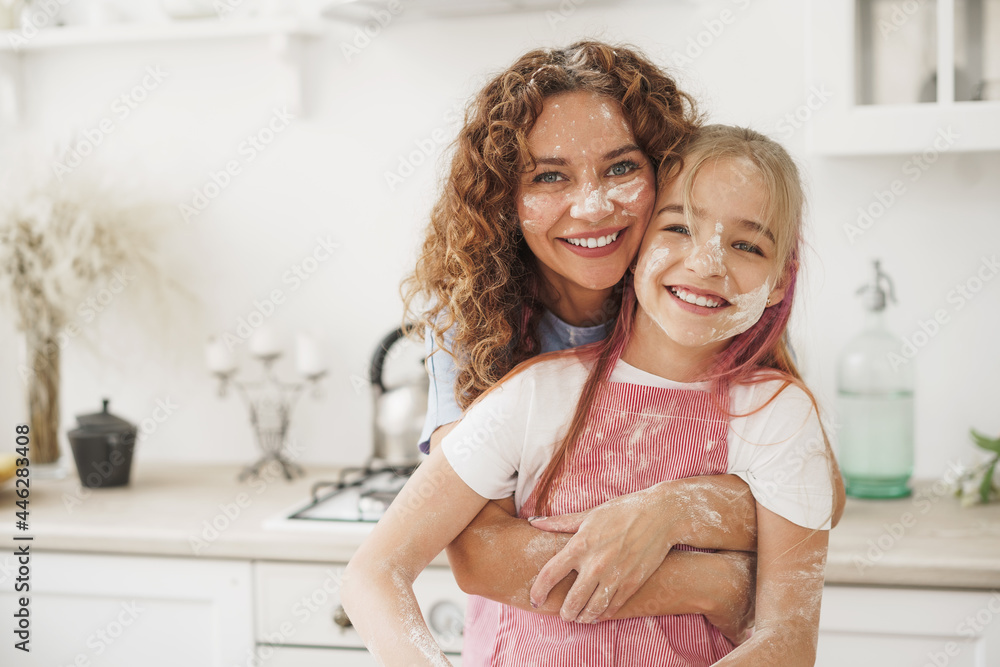 Mother and daughter having fun while cooking dough in kitchen Mother and daughter having fun while cooking dough in kitchen