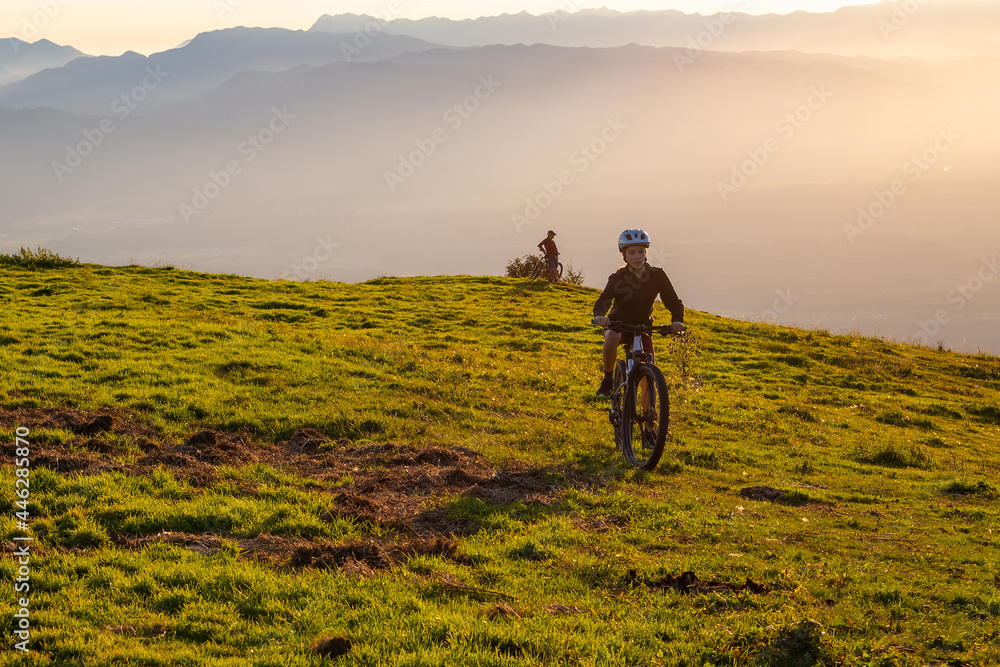 Girl child riding mountain bike into the sunset. Beautiful golden summer light. Girl child riding mountain bike into the sunset. Beautiful golden summer light.