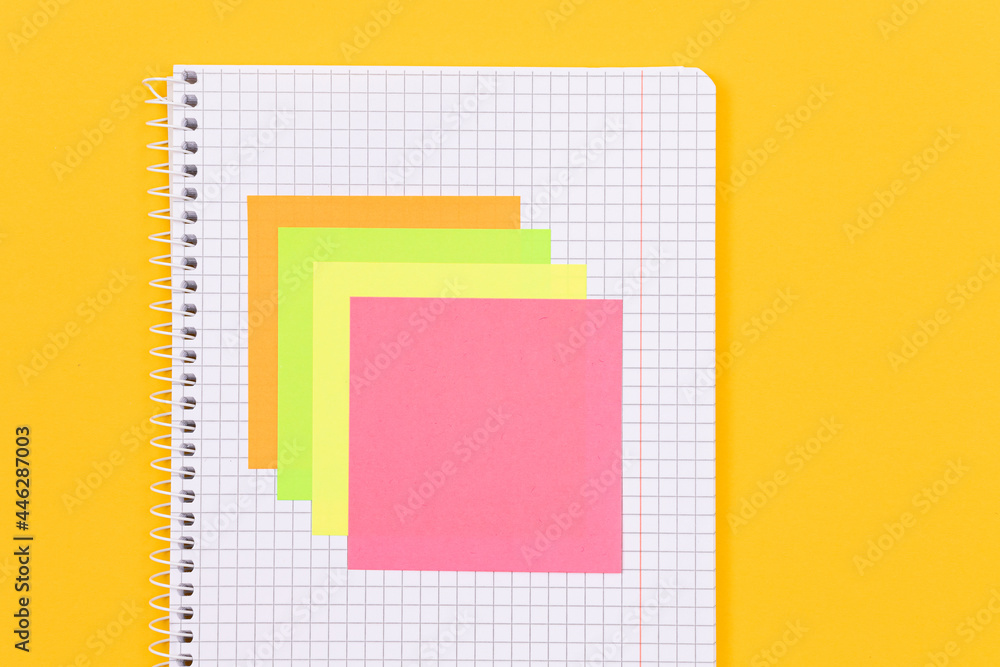 A Notepad with Sticky Notes Lying on Yellow Table - Blank Template. Top View, Flat Lay A Notepad with Sticky Notes Lying on Yellow Table - Blank Template. Top View, Flat Lay