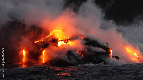 Lava running in the ocean from volcanic lava eruption on Big Island Hawaii. Seen from lava boat tour. Lava from Kilauea volcano by Hawaii volcanoes national park, USA