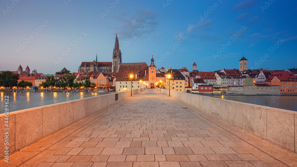 Regensburg, Germany. Panoramic cityscape image of Regensburg, Germany with Old Stone Bridge over Danube River and St. Peter Cathedral at summer sunrise.