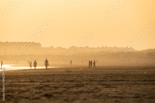 sunset on the beach of huelva with silhouettes of people