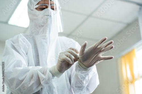 medical staff or emaergency paramedic doctor in PPE suit wearing protective mask and white rubber glove preparing for helping patient in hospital