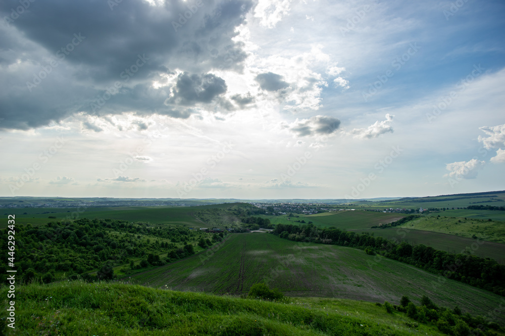 Fototapeta premium Summer landscape and white clouds over green fields