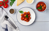 Italian dish, gnocchi with tomato sauce and basil, potato dumplings, on a white wooden table, , no people, top view, 