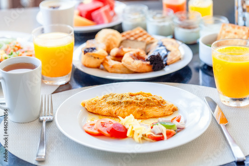 Breakfast Buffet in Luxury Hotel  Omelette and Fresh Desserts  Buns  Croissant. Dining Table with Plate of Delicious Food. Food in Hotel with Plates Full of Food  Orange Juice in Glass and Coffee Cups