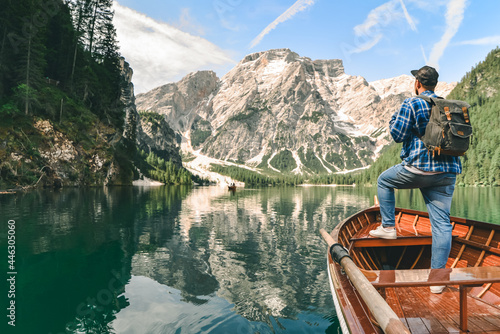 man in big wooden boat at mountain lake