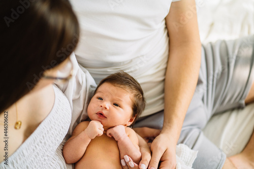 Fotografi Caucasian parents with newborn baby, Close up portrait of young couple holding their new born baby girl
