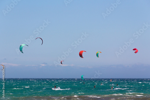 Seascape with people practicing kitesurfing. Sea sport.