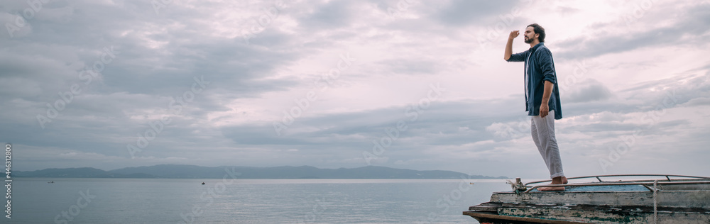 A lonely man walks along the beach on a cloudy day