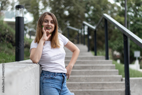 Outdoor portrait of a young woman in casual clothing on concrete stairs.