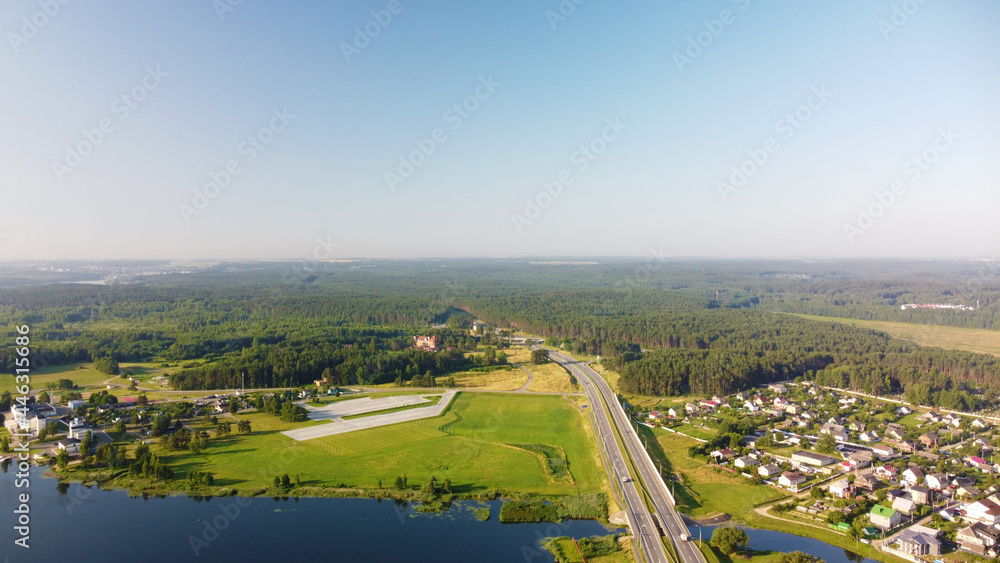 Aerial view of highway road and green meadows and fields