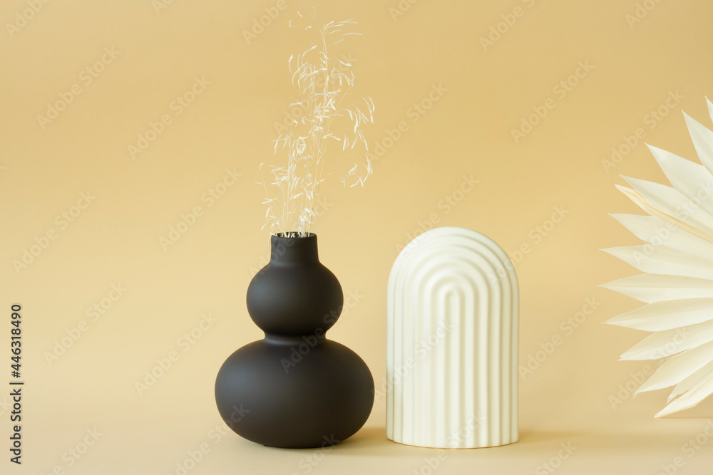 Black matte vase and plaster figure on delicate background