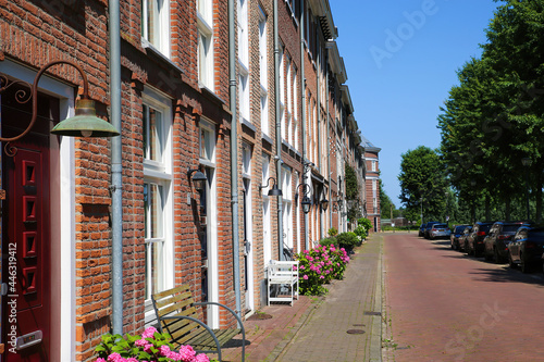 Helmond, Netherlands - July 10. 2021: View on street with red asphalt and typical dutch old houses in summer with blue sky