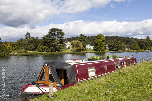 A narrow boat moored opposite Greenlands on the River Thames at Hambleden, Buckinghamshire, UK photo