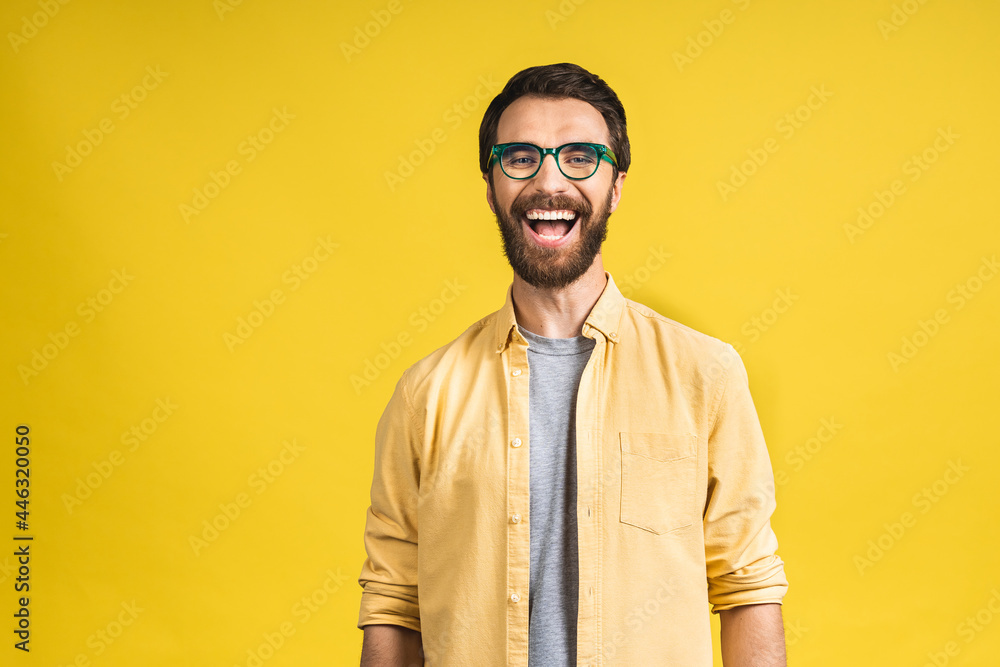 Happy young man. Portrait of handsome young bearded man in casual smiling while isolated over yellow background. Happy young man. Portrait of handsome young bearded man in casual smiling while isolated over yellow background.