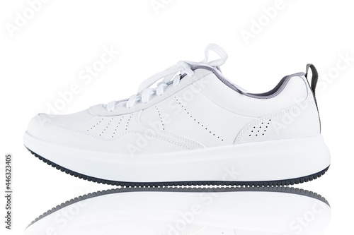 White new sneaker isolated on white background with reflection. Sport shoe close up. Street fashion style