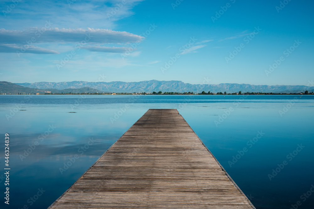 Seascape with wooden breakwater. Morning of blue sky and sea. Symmetrical image. Peace, tranquility, solitude, calm, relaxation, yoga, zen, spirituality Seascape with wooden breakwater. Morning of blue sky and sea. Symmetrical image. Peace, tranquility, solitude, calm, relaxation, yoga, zen, spirituality