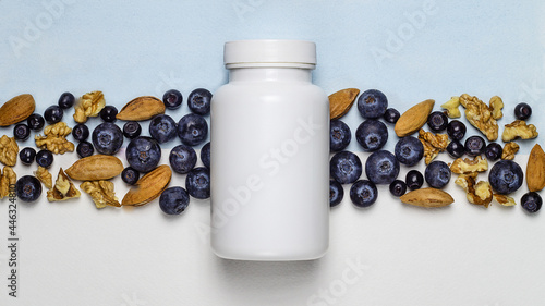 White plastic jar with dietary supplements or vitamines photo