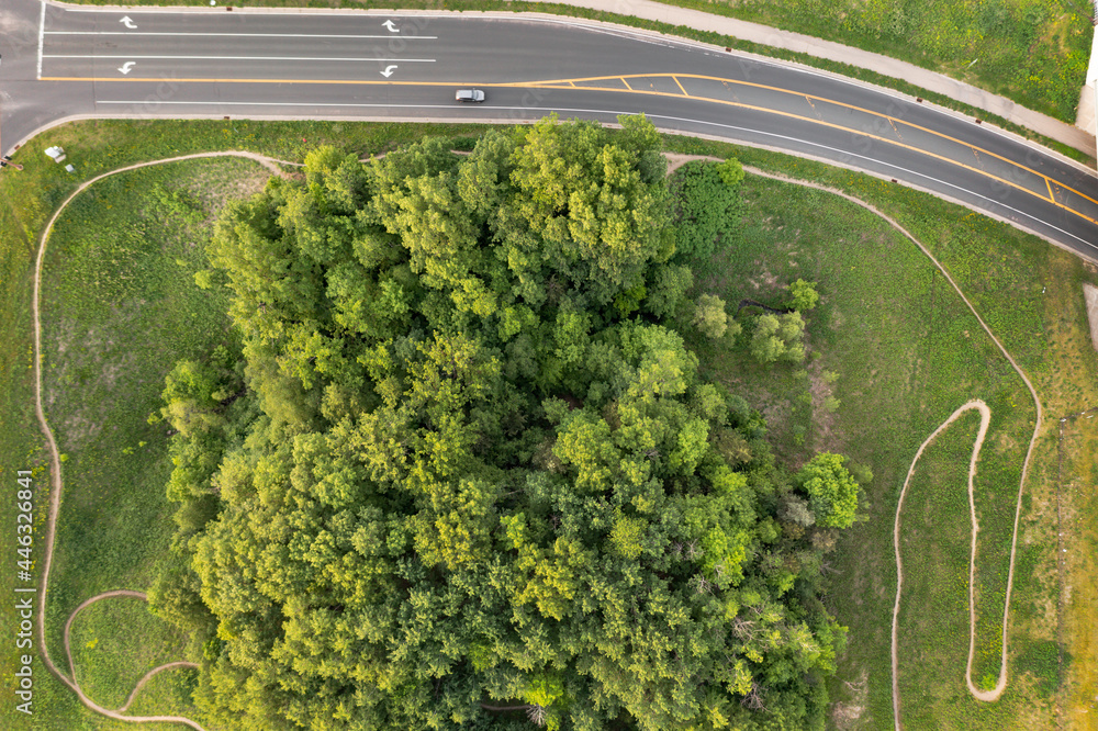 single-track-off-road-bike-trail-going-around-trees-and-road-aerial