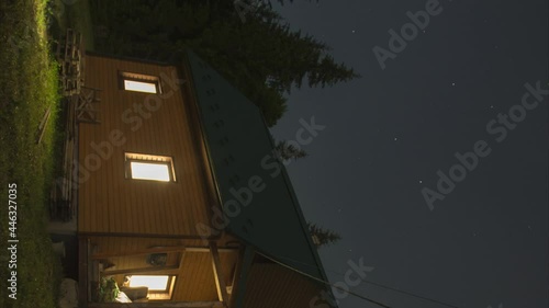 Vertical video, a house in the mountains against the background of the starry sky, time lapse