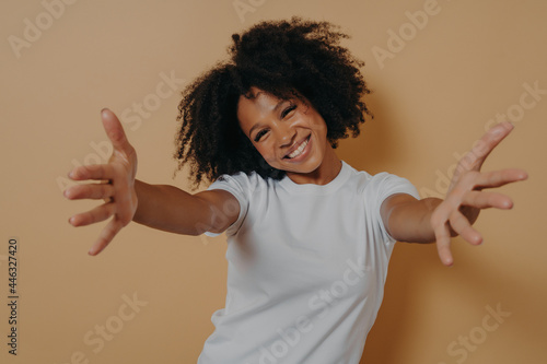 Принти на полотні Happy friendly African American woman dressed in white shirt offering hugs, welc