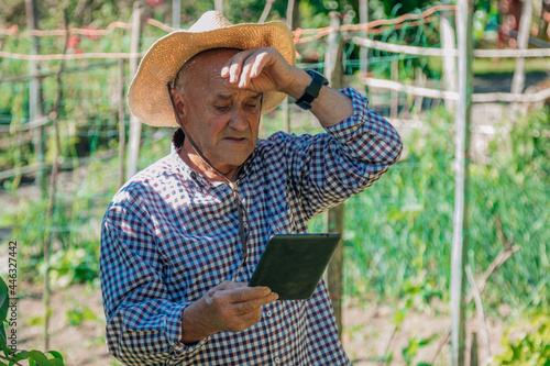 farmer in the field with new technology or device © carballo